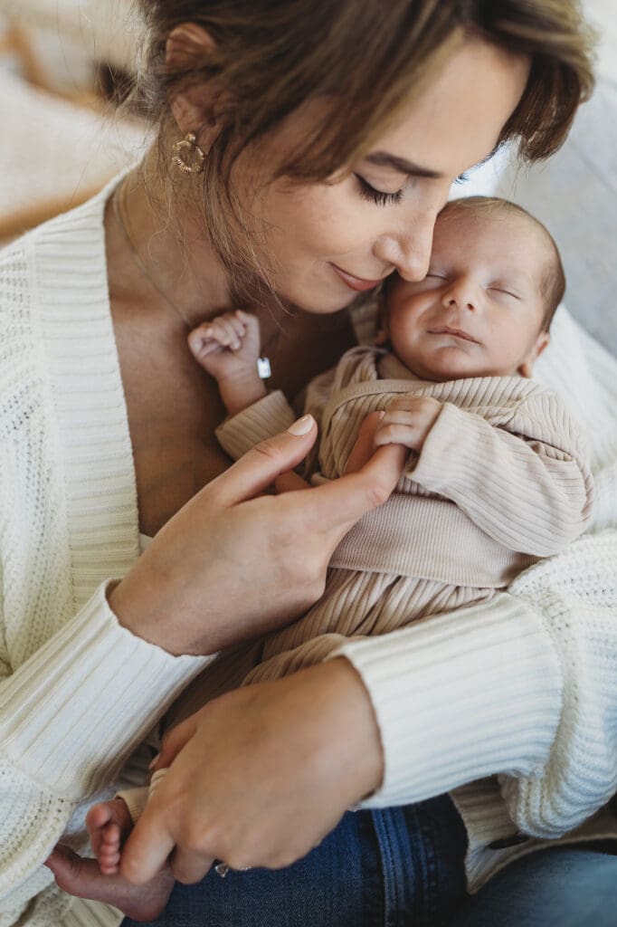 Atlanta newborn photographer capturing a quiet lifestyle moment of mother holding her rainbow baby in natural light at home