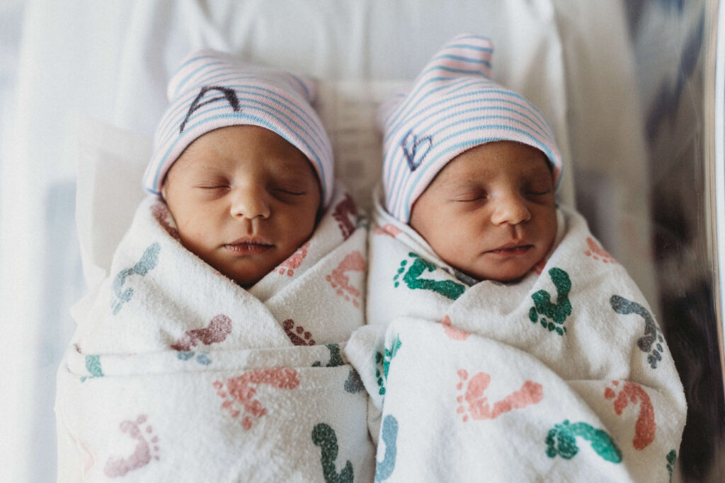 Newborn twin boys snuggled together in hospital bassinet during their Fresh 48 session at Piedmont Hospital.
