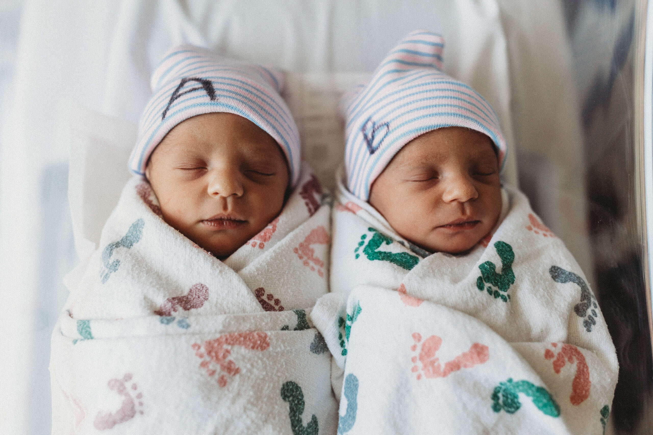 Newborn twin boys snuggled together in hospital bassinet during their Fresh 48 session at Piedmont Hospital.