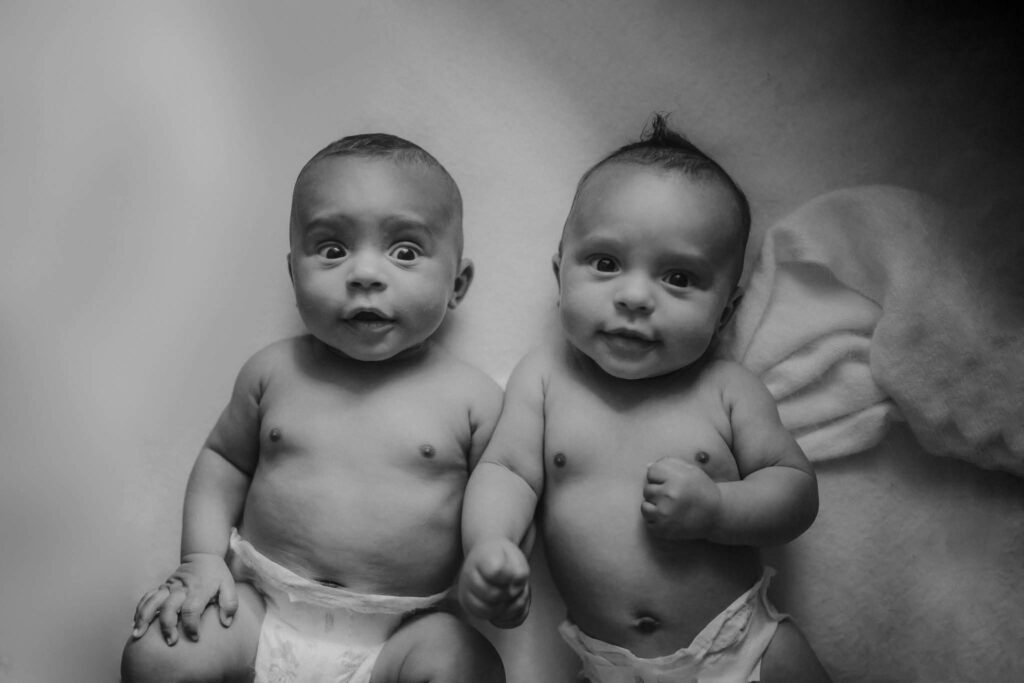 Atlanta newborn photography of twin babies looking at the camera during cozy lifestyle session