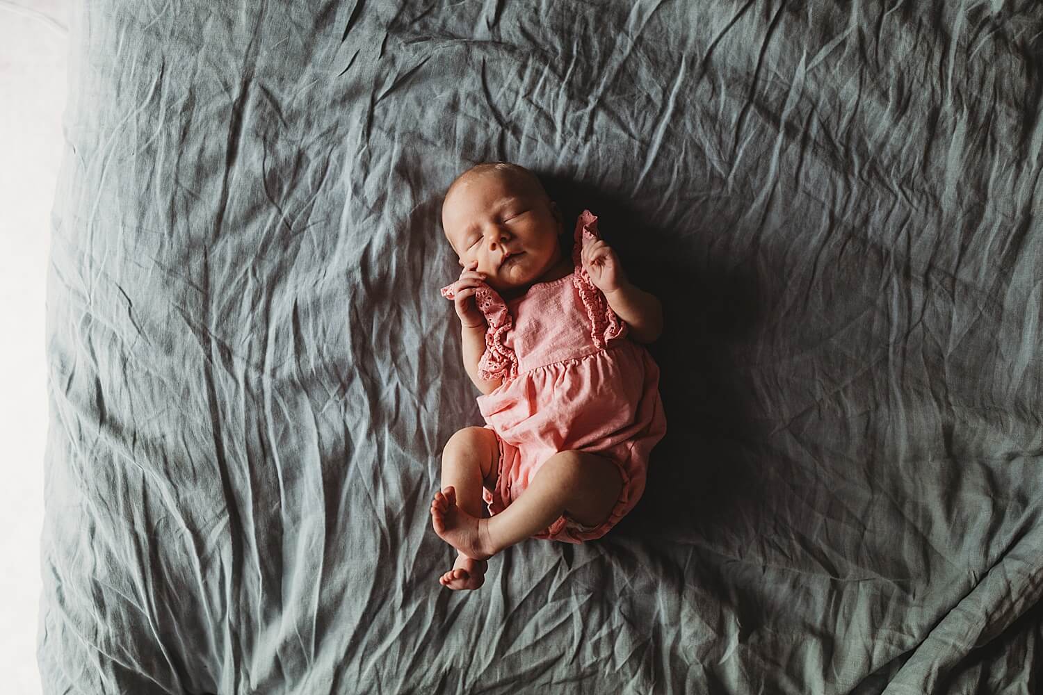 Atlanta newborn photographer capturing newborn baby girl in pink outfit during in-home lifestyle newborn session in Grant Park