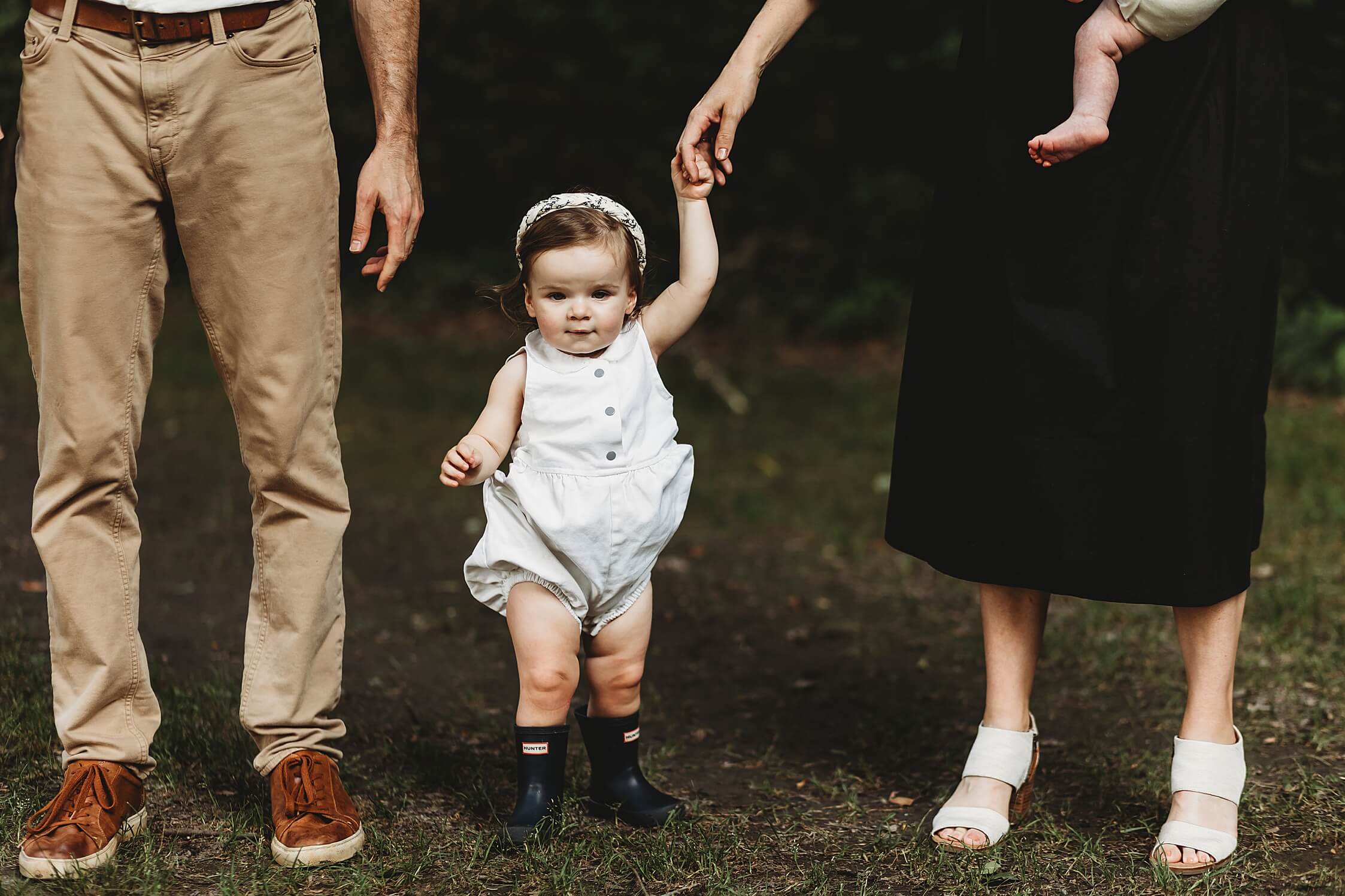 Atlanta newborn photographer capturing candid big sister with family walking