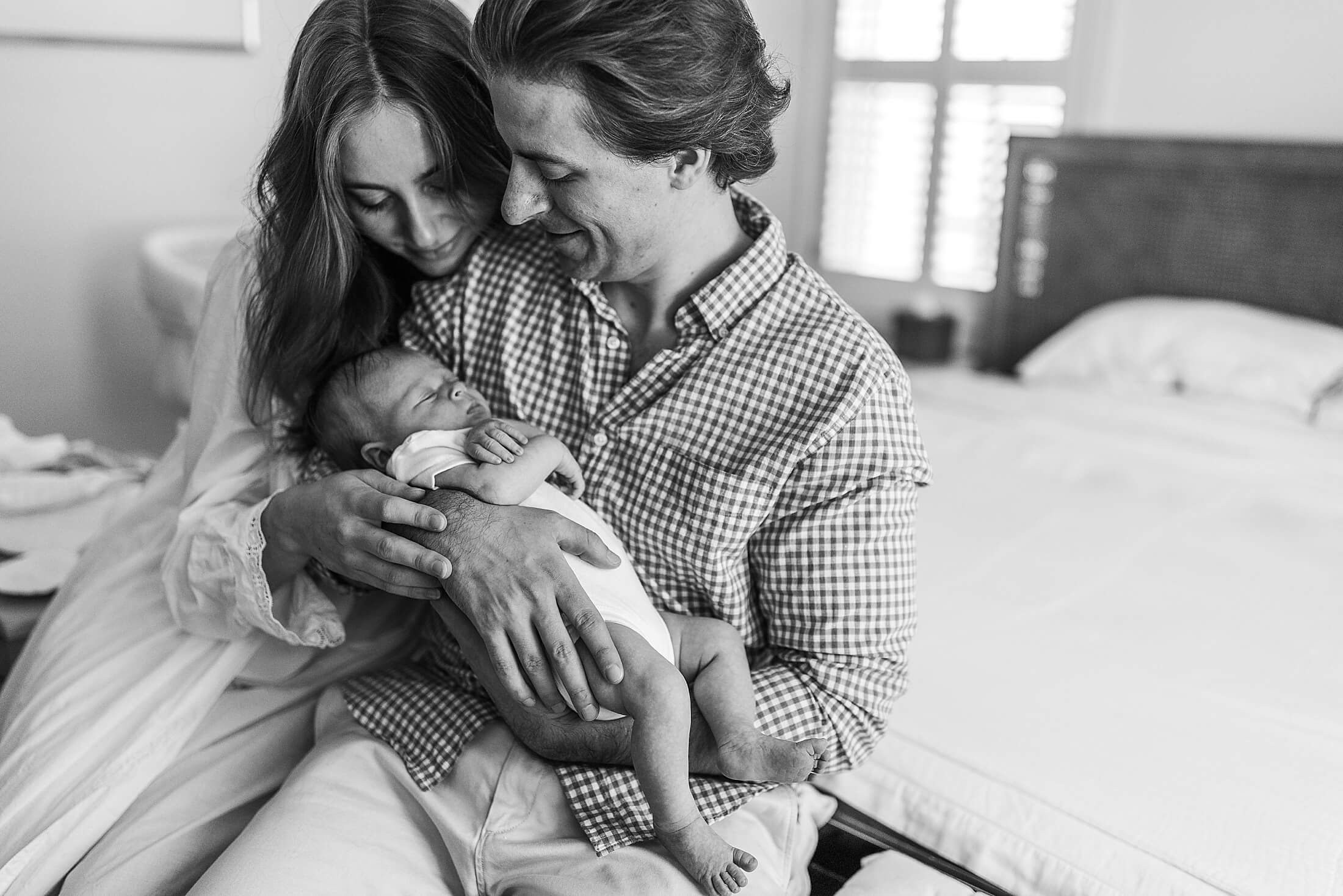 Black and white editorial family portrait with parents and newborn during a luxury in-home newborn session in Buckhead, Atlanta