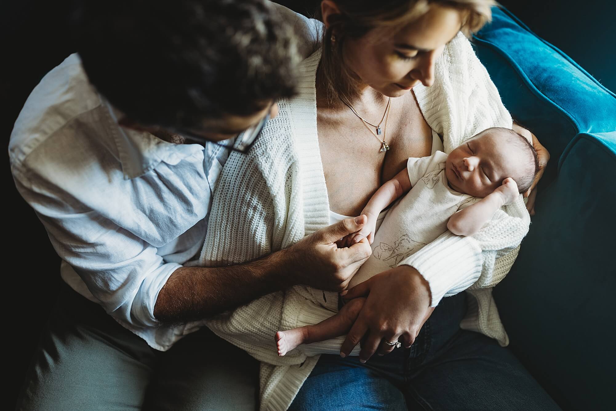 Atlanta editorial newborn photography of parents holding baby in moody room