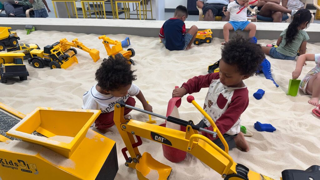 Twin boys playing with sand at Isaac's Sandlot Chamblee. A great toddler activity in Atlanta.