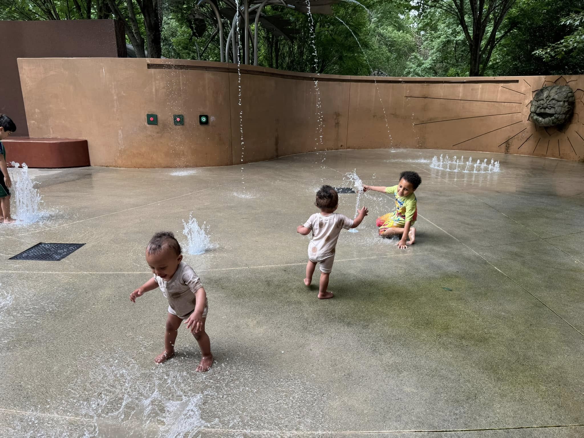 Kids enjoying the splash pad at Atlanta Botanical Garden on a hot summer day in Atlanta, Georgia.