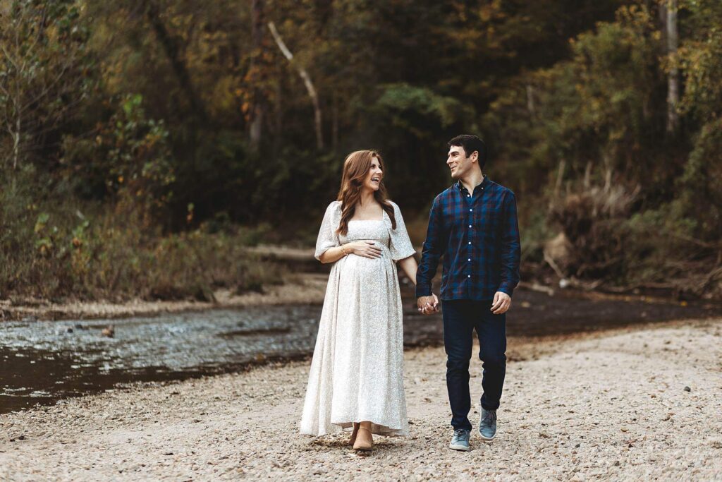 Expecting family embracing during an outdoor maternity session after fertility treatment in Atlanta.
