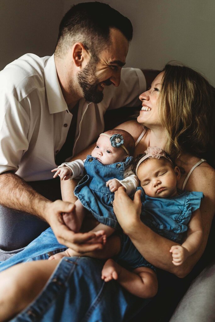 Parents holding their twin newborn girls during a candid in-home lifestyle newborn photography session in Atlanta.