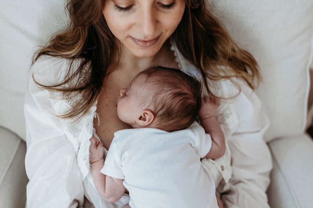 Mother holding her newborn close in a calm and comforting moment at home