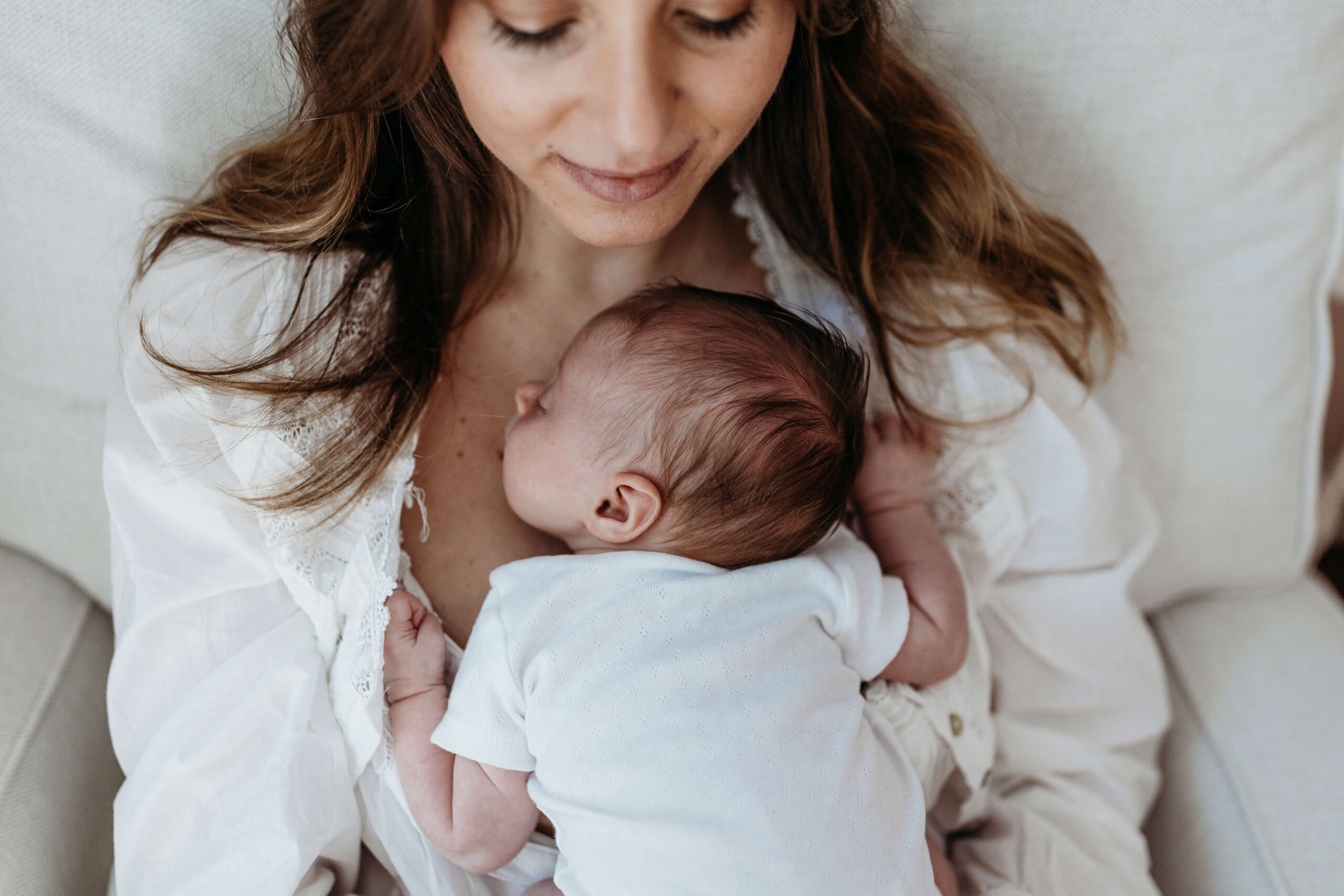 New mom holding her baby at home during the first months of motherhood.