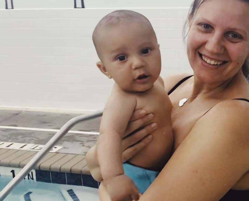 Parent participating in a baby swim lesson with an infant