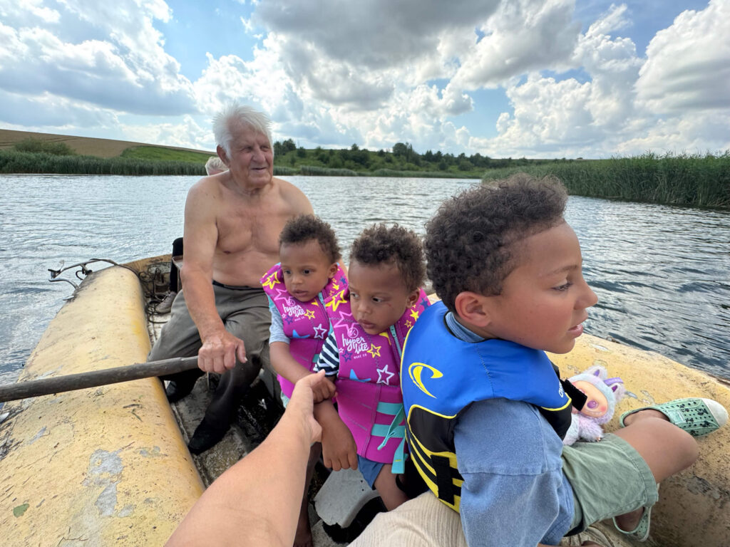 Children fishing with their grandpa after flying with a baby to visit family overseas.