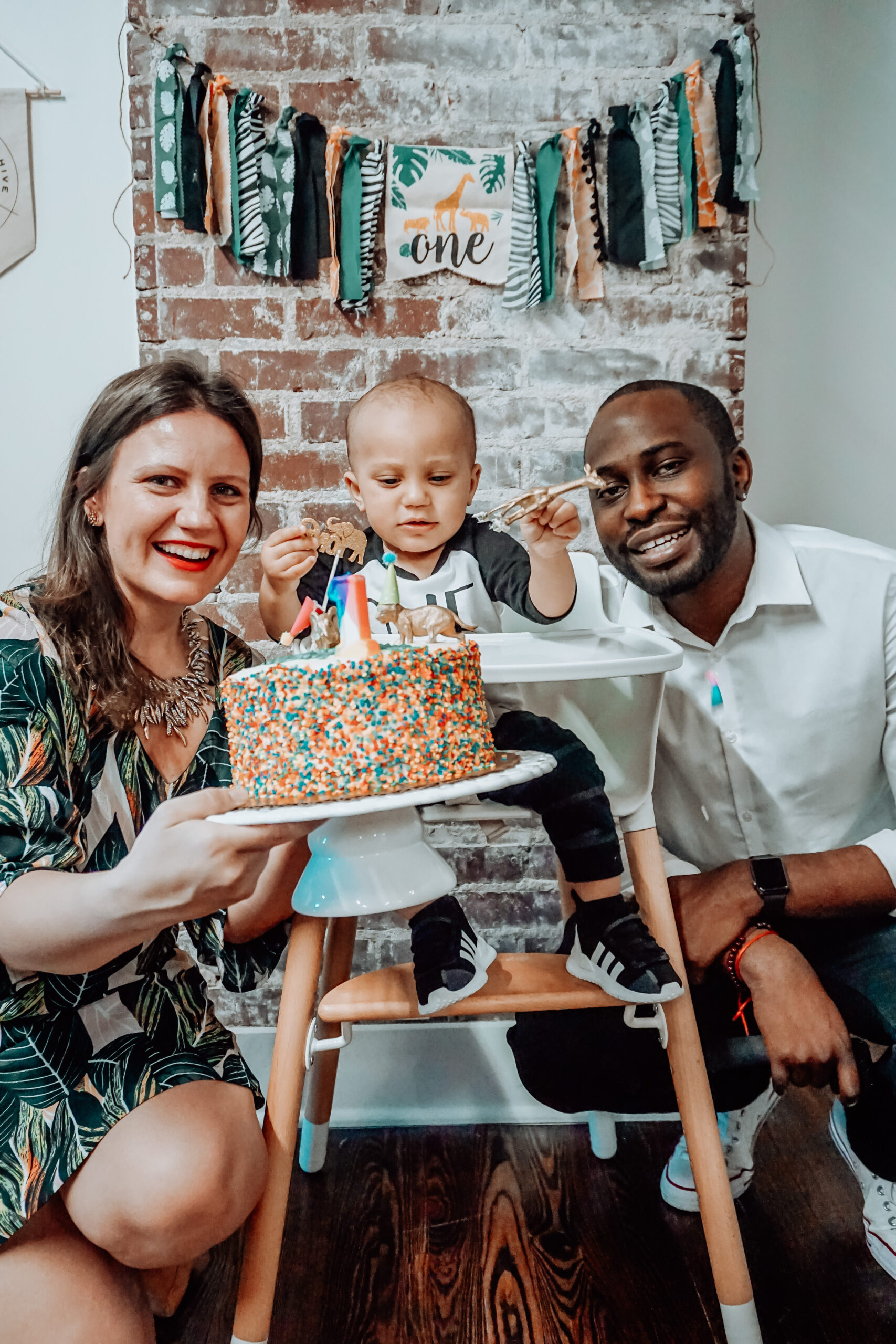 Parents holding a birthday cake during a family celebration at The Bunny Hive in Atlanta, a charming venue for intimate baby showers and children's parties.