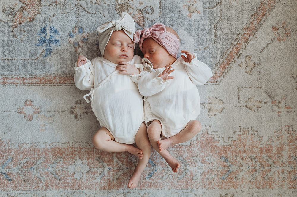 Twin babies laying on the ground during atlanta newborn session