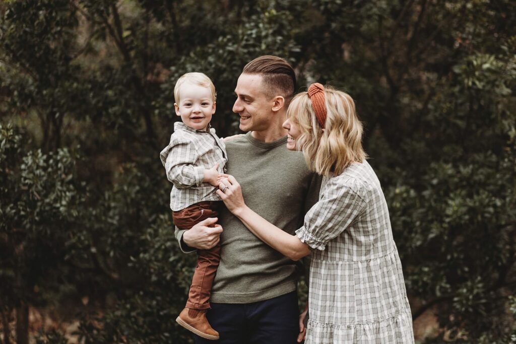 Mom and dad holding their toddler while talking about finding the best nannies in Atlanta